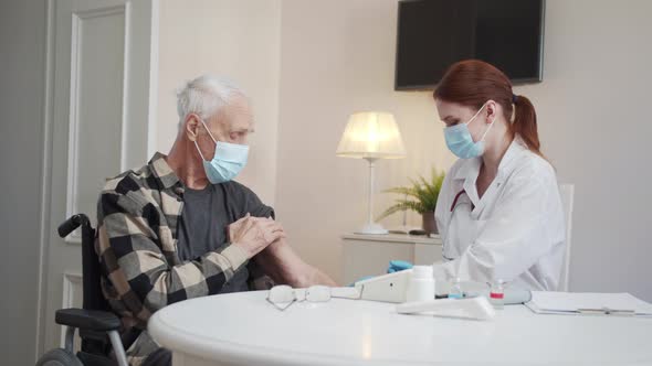 The Doctor Makes a Vaccination to a Pensioner and Shows the Thumb