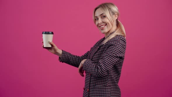 The Young Woman in the Side Profile Holds a Glass of Coffee in Her Hand and Smiling Recommends