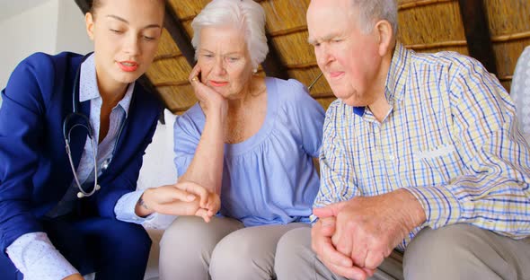 Front view of Caucasian female doctor discussing medication with senior couple at comfortable home 4