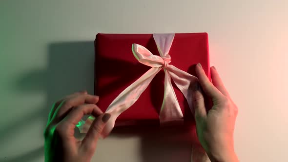 Woman Hand Unwrap a Gift Close Up