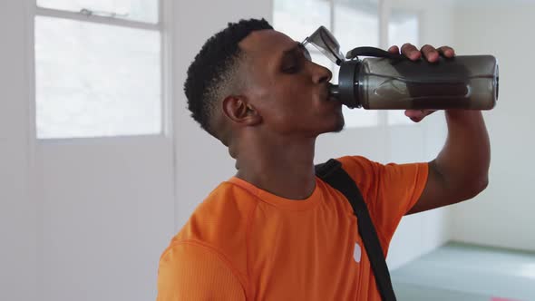 Mixed race man drinking water