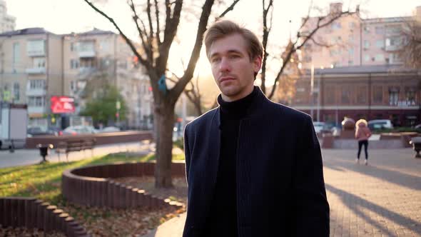 Serious Handsome Business Man Walks After Work in the Sunset Light of the City.