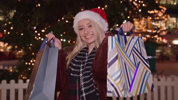 Attractive youth holds up her recent purchases from her shopping trip