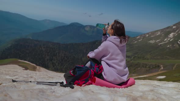 Woman Mountain Hiker Taking Ease and Drinking Water