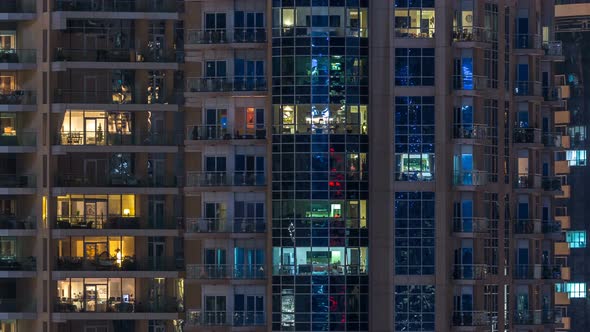 Glowing Windows in Multistory Modern Glass Residential Building Light Up at Night Timelapse