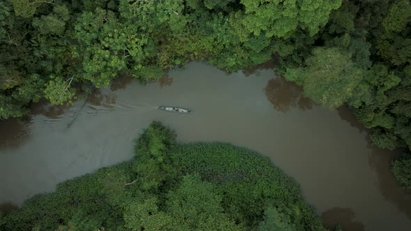 Top View Of A Sailing Wooden Boat On A Calm River In Tropical Forest. Aerial Drone Shot