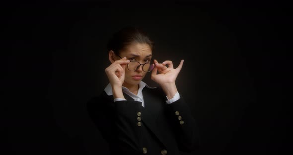 Business Woman with Glasses with a Dissatisfied Expression Looks at the Camera