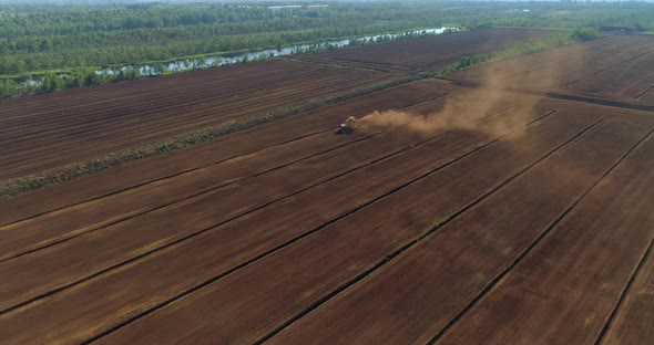 Peat Harvesting Aerial View Tractor Collecting Peat Dust on Dry Bog Field