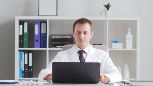 Professional medical doctor working in hospital office using computer technology.