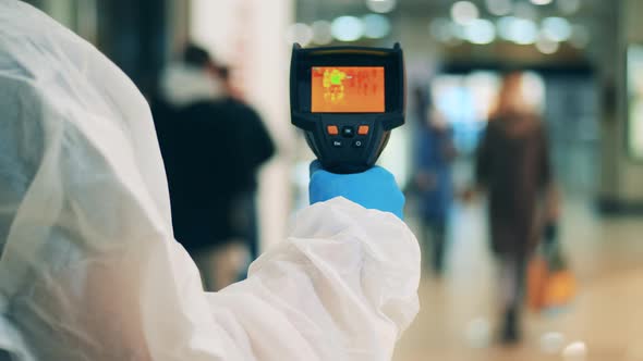 Medical Expert Is Using a Thermographic Device in a Public Place. Body Temperature Detecting, Covid