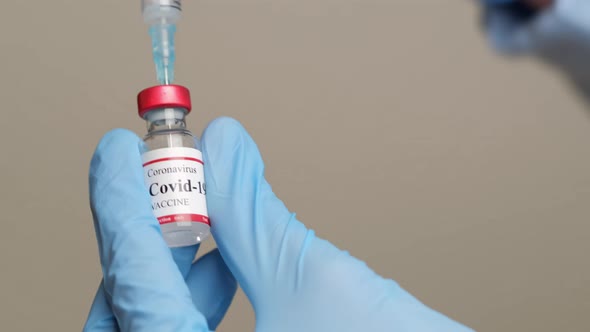 Doctor Holding Coronavirus Vaccine and Syringe to Prevent COVID19 Infection