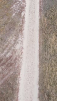 Vertical Video a Dirt Road Through an Empty Field