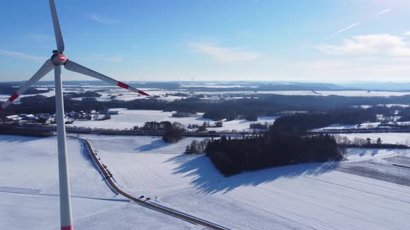 Flying towards a wind turbine in the sun. Aerial view of a rotating wind turbine.