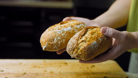 The Woman Demonstrates in Her Hands Two Freshly Baked Bread Sticks