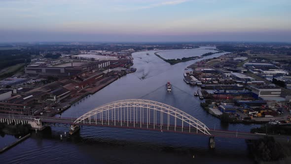 Sunset aerial view of bridge over the Noord with cargo ships passing by inland ports Alblasserdam Ne