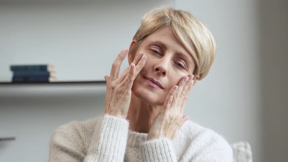 An Attractive Middleaged Woman Touching the Skin of Her Cheek the Concept of Mature Beauty