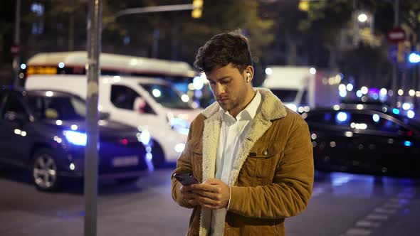 Man Using Smartphone on Night Street