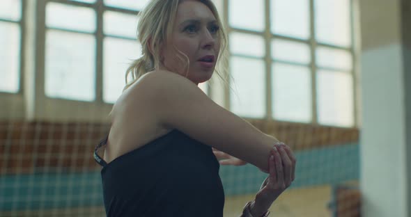 Sporty Young Woman in Black Sportswear Stretching Arms and Back Muscles Before Workout