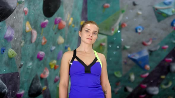 Female Climbing Enthusiast Posing next to Colorful Walls