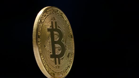 Gold Bitcoin Rotates on a Black Background