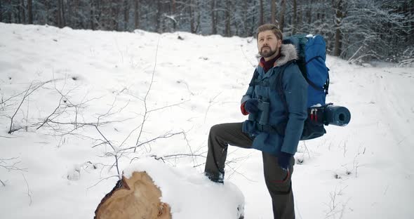 Bearded Man Looking on Snowy Nature Through Binoculars