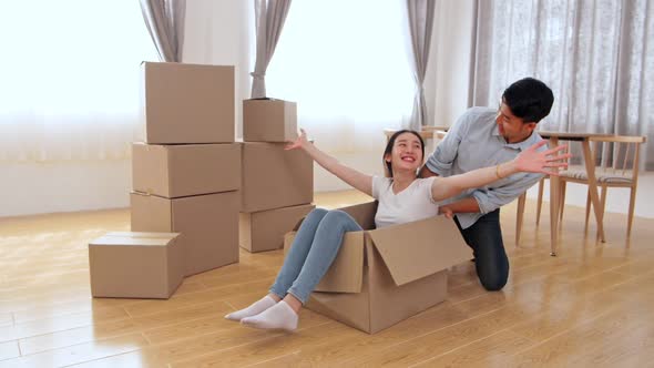 Happy Couple Is Having Fun With Cardboard Boxes In New House At Moving Day