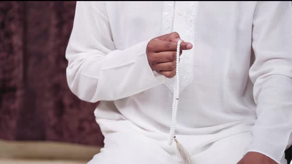 Muslim man using praying beads