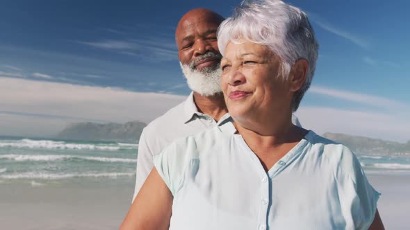 Smiling senior african american couple embracing at the beach