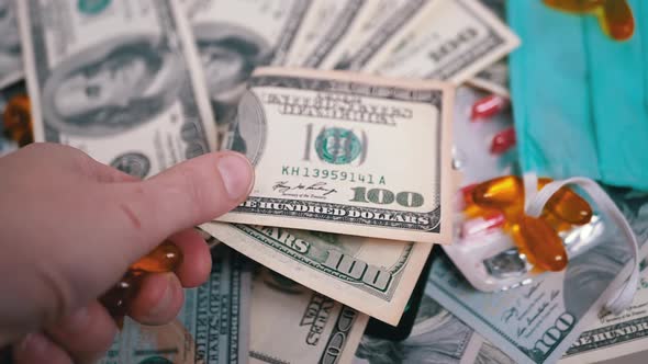 Man Hand Holds Out Money US Dollars for Purchase Orange Pills