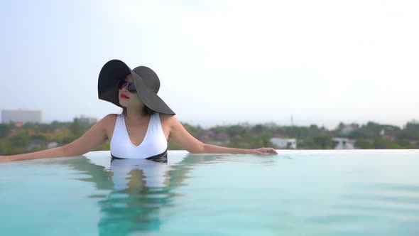 Young asian woman enjoy around outdoor swimming pool for leisure