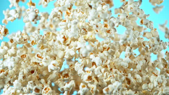 Super Slow Motion Shot of Popcorn on Blue Background After Being Exploded at 1000Fps
