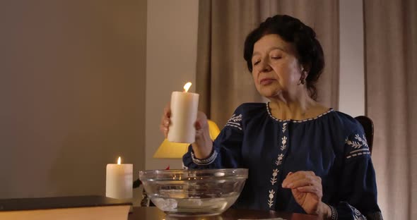 Close-up of Mature Caucasian Woman Pouring Candle Wax Into Water