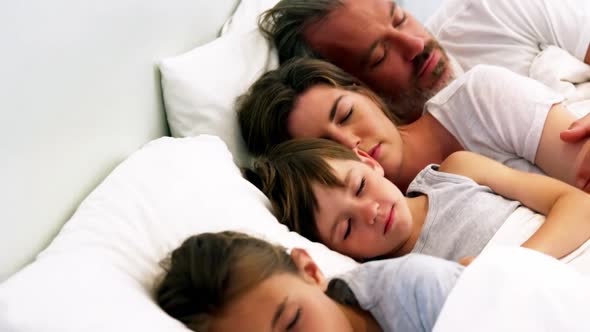 Family sleeping in bedroom