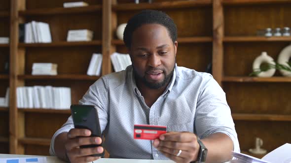 Sad AfricanAmerican Guy with Phone and Credit Card