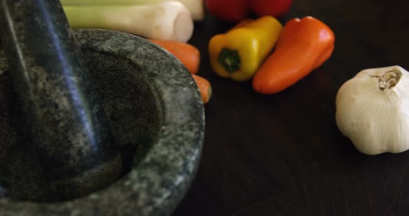 Mortar,pestle and vegetables on kitchen worktop