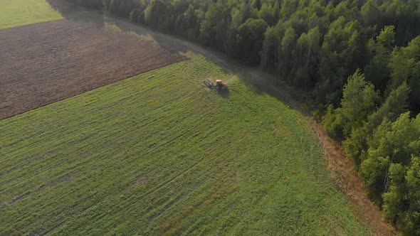 Farmer on Tractor Turns Around Near Forest