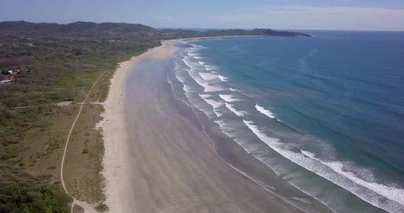 Aerial drone view of the beach, rocks and tide pools in Guiones, Nosara, Costa Rica.