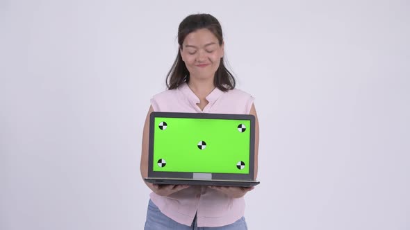 Young Happy Asian Businesswoman Thinking While Showing Laptop