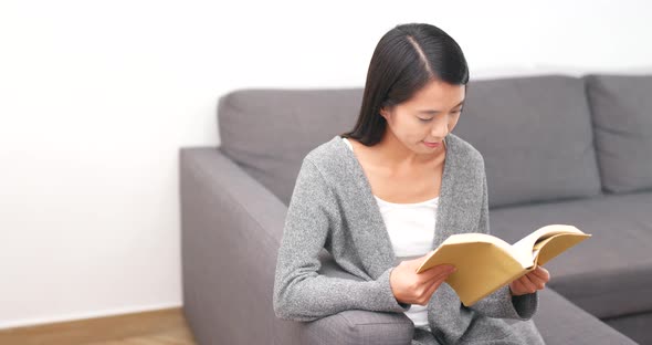 Woman reading book at home