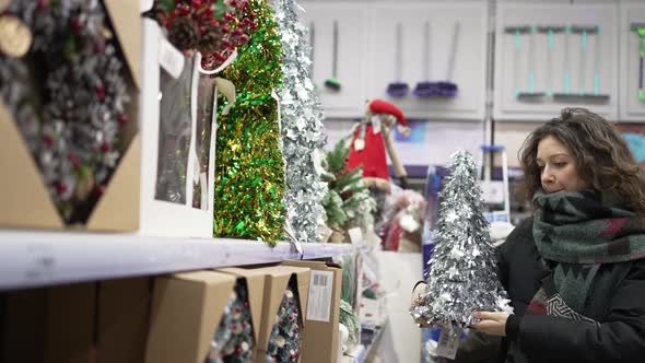 Woman with Curly Hair Buys Christmas Decorative Wreath