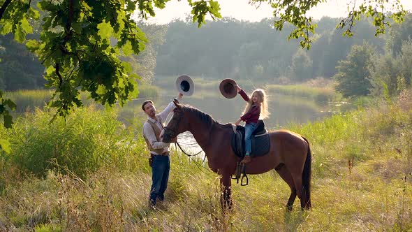 Cowboy and His Daughter on Horseback