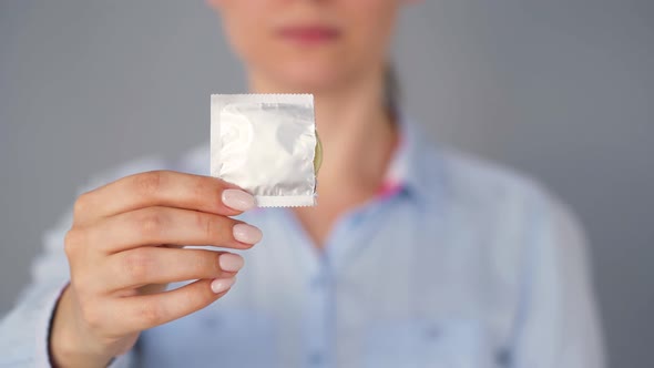 Female Hands Demonstrating Condom Before Camera, Safe Sex, Contraception