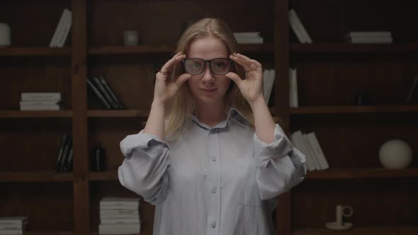 Portrait of Young Blonde Woman Taking Off and on Eye Glasses Smiling and Looking at Camera Standing