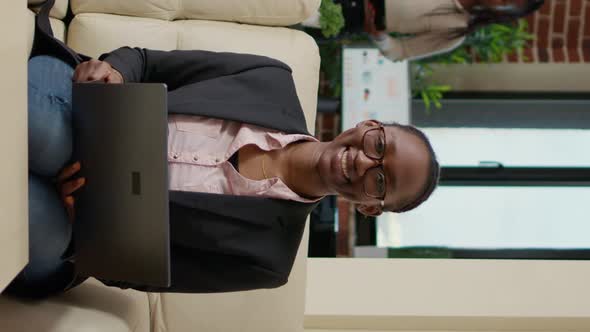 Vertical Video Portrait of African American Woman Holding Laptop on Sofa