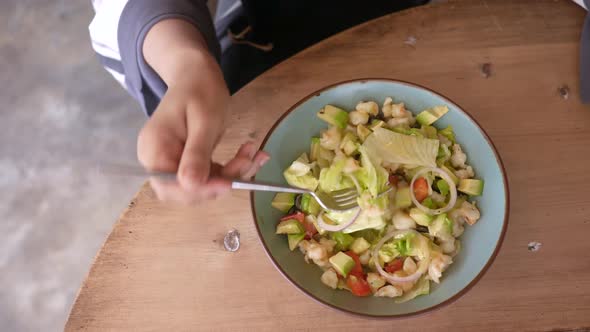 Young Women Eating Avocado Salad