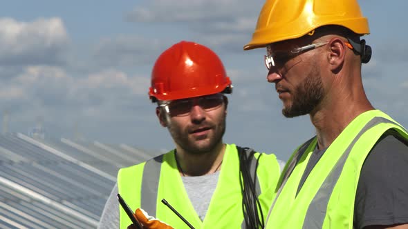 Male Engineers Discussing Plans of Solar Power Station
