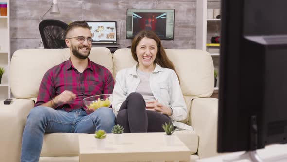 Charming Young Couple Sitting on the Couch and Watching Tv