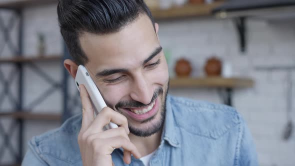 Headshot of Cheerful Middle Eastern Young Man Talking on the Phone Smiling As Caucasian Woman