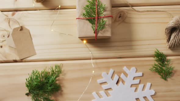 Video of christmas decorations with presents and tag on wooden background