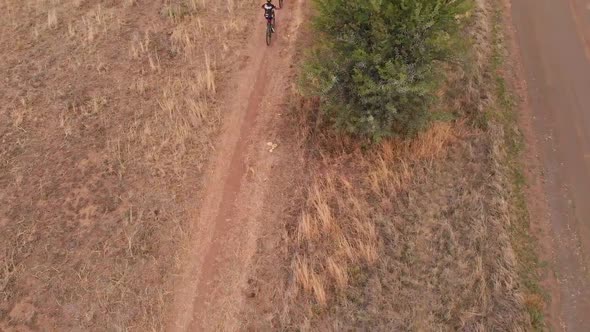 Drone Following Two Mountain Bikers on a Overcast Day